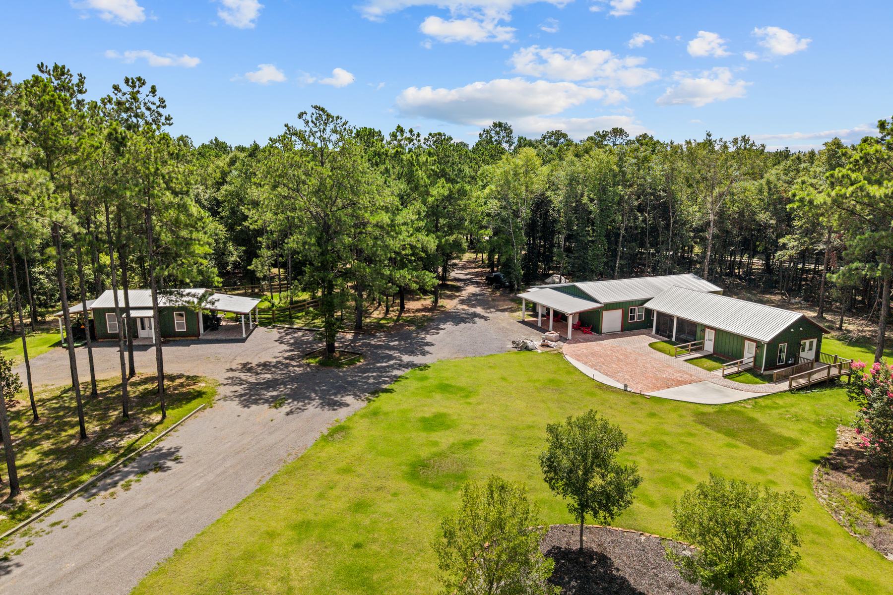 Aerial view of the Riverhouse Create studios and lawn surrounded by pine woods