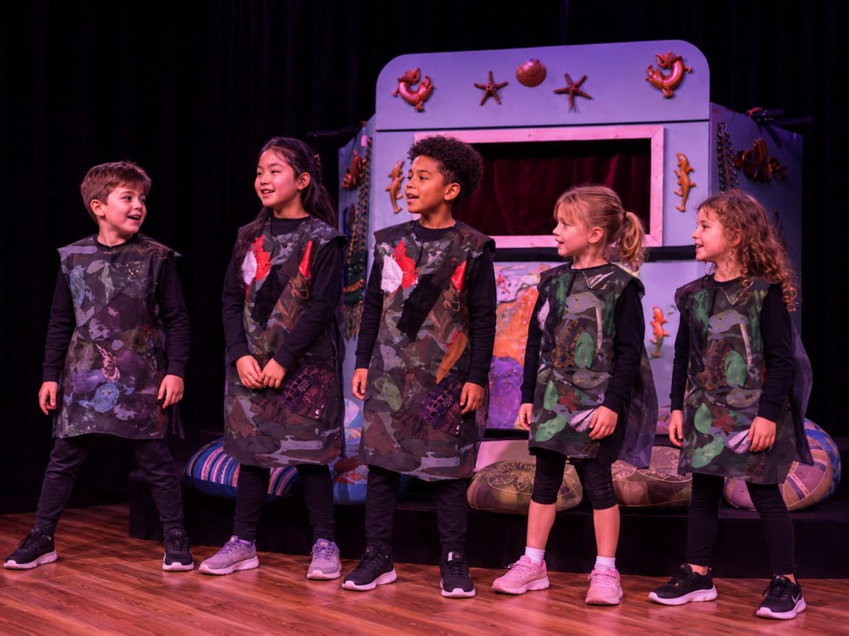 Five young performers singing together on the Riverhouse stage